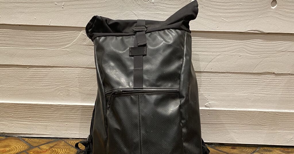 Chrome Black Backpacks for School - bag is sitting on a wood tile floor against a white shiplap wall