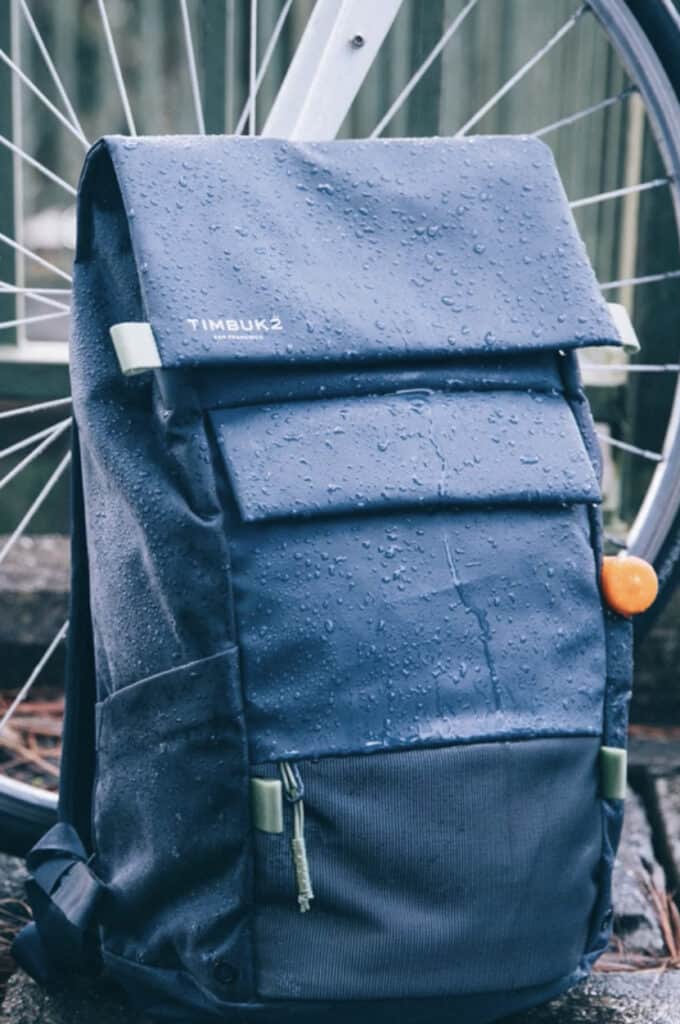 Timbuk2 blue waterproof backpack with drops of rain on it